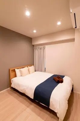 a bedroom with a large white bed with a blue blanket at VOERE亀戸 - Kameido Modern Suite - Direct to Akihabara & Shinjuku - Near Asakusa, Skytree in Tokyo