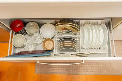a drawer filled with plates and dishes in a refrigerator at Higashi koiwa 4 Bed rooms Villa 5 minutes walk from JR Koiwa station 60min friom Haneda airport in Tokyo