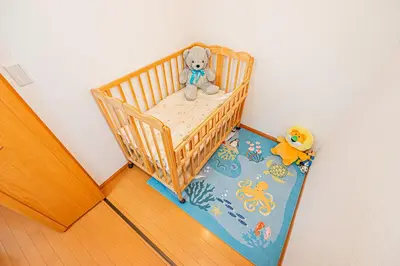 a crib with a teddy bear sitting in it at Higashi koiwa 4 Bed rooms Villa 5 minutes walk from JR Koiwa station 60min friom Haneda airport in Tokyo