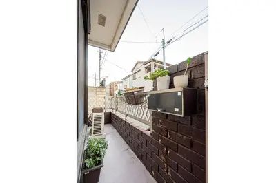 a balcony with a tv on a brick wall at Higashi koiwa 4 Bed rooms Villa 5 minutes walk from JR Koiwa station 60min friom Haneda airport in Tokyo
