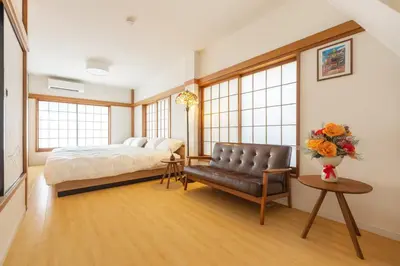 a bedroom with a bed and a couch and windows at Witch's House Walk to Ikebukuro Tokyo's Ghibli Fairy Tale House in Tokyo