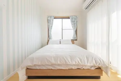 a bedroom with a bed with white sheets and a window at Witch's House Walk to Ikebukuro Tokyo's Ghibli Fairy Tale House in Tokyo