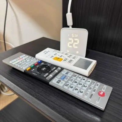 two remote controls sitting on top of a table at Entire House 3 Mins Walk from JR station - Family welcome in Tokyo