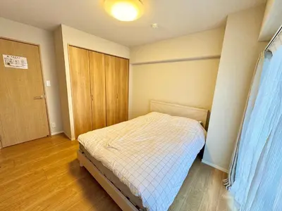 a small bedroom with a bed and a wooden door at \u5317\u6ca2\u611b\u306e\u65c5 in Tokyo