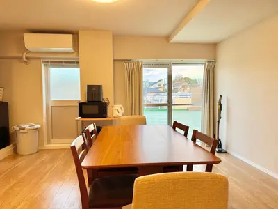 a dining room with a wooden table and chairs at \u5317\u6ca2\u611b\u306e\u65c5 in Tokyo