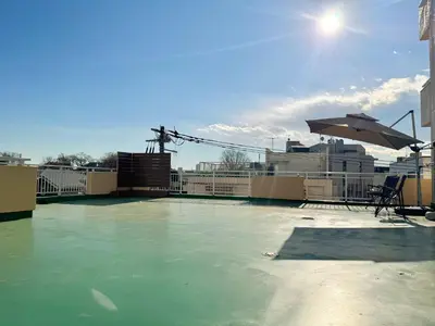 a swimming pool with an umbrella and a table and chair at \u5317\u6ca2\u611b\u306e\u65c5 in Tokyo