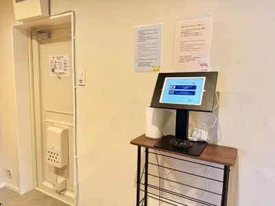 a computer on a stand on a table next to a door at \u5317\u6ca2\u611b\u306e\u65c5 in Tokyo