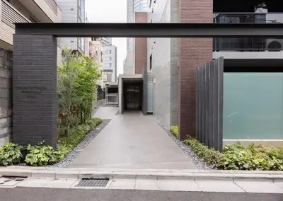 a walkway between two buildings with a large window at Mocomoco House Azabu in Tokyo