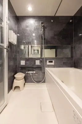 a bathroom with a tub and a toilet and a sink at Mocomoco House Azabu in Tokyo