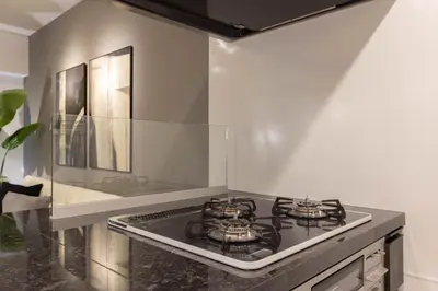 a kitchen with a stove top oven next to a wall at Mocomoco House Azabu in Tokyo