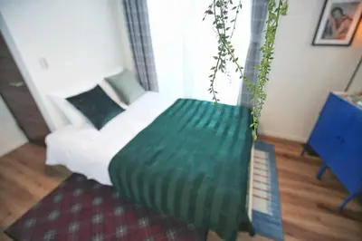 a bedroom with a bed with a green blanket at SG5371 Visit Shibuya Crossing! Walking distance to a single family home for 8 people, private parking , downstairs supermarket food Shibuya in Tokyo