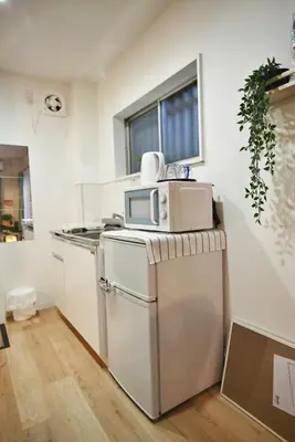 a kitchen with a microwave on top of a refrigerator at BRT101 Ikebukuro Station , Double Apartment , Yamanote Line direct access to Shinjuku Shibuya, convenient transportation, fully equipped in Tokyo