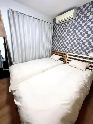 two beds sitting next to each other in a bedroom at 101 Nishi Shinjuku Gochome Station 5 minutes on foot in Tokyo