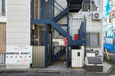 a building with a blue staircase in front of a building at 101 Nishi Shinjuku Gochome Station 5 minutes on foot in Tokyo