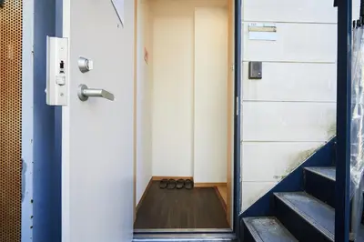 a pair of shoes sitting on the floor next to a door at 101 Nishi Shinjuku Gochome Station 5 minutes on foot in Tokyo