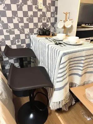 a table with a black chair and a table with plates and bowls at 101 Nishi Shinjuku Gochome Station 5 minutes on foot in Tokyo