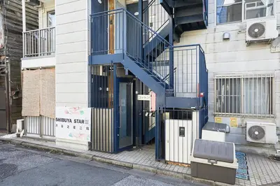a building with a blue staircase on the side of it at 101 Nishi Shinjuku Gochome Station 5 minutes on foot in Tokyo