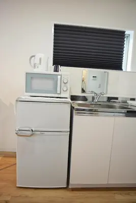 a white kitchen with a microwave and a sink at BRT203 Ikebukuro Station Double Apartment in a Busy Business District, Yamanote Line and 8 Subway Lines Direct to Shinjuku, Shibuya, Ginza, Akihabara, Fully Equipped in Tokyo