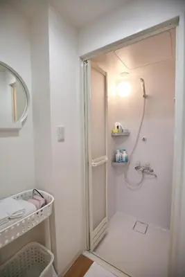 a white bathroom with a shower and a mirror at BRT301 Ikebukuro Station Double Apartment in a Busy Business District, Yamanote Line and 8 Subway Lines Direct to Shinjuku, Shibuya, Ginza, Akihabara, Fully Equipped in Tokyo