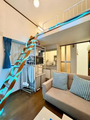 a living room with a couch and a loft bed at torico takinogawa in Tokyo