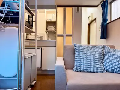 a living room with a couch and a kitchen at torico takinogawa in Tokyo