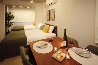 a room with a bed and a table with wine glasses at Monzen-Nakacho Stylish 1LDK with 2 Double Beds in Tokyo