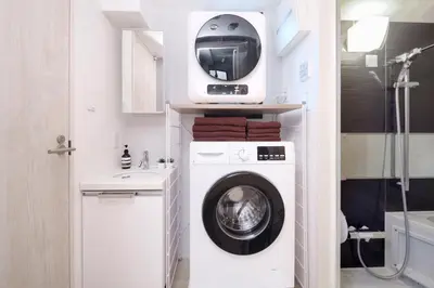 a bathroom with a washing machine and a tv at Monzen-Nakacho Stylish 1LDK with 2 Double Beds in Tokyo