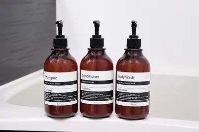 three bottles of hot sauce sitting on a white shelf at Monzen-Nakacho Stylish 1LDK with 2 Double Beds in Tokyo