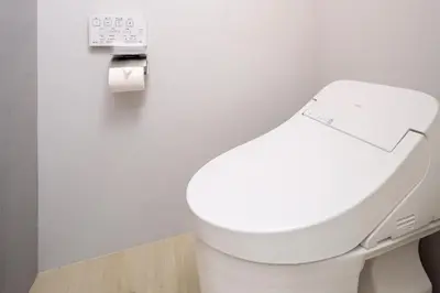 a white toilet in a bathroom with a toilet paper dispenser at Monzen-Nakacho Stylish 1LDK with 2 Double Beds in Tokyo