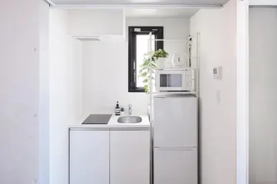 a white kitchen with a refrigerator and a sink at Monzen-Nakacho Stylish 1LDK with 2 Double Beds in Tokyo