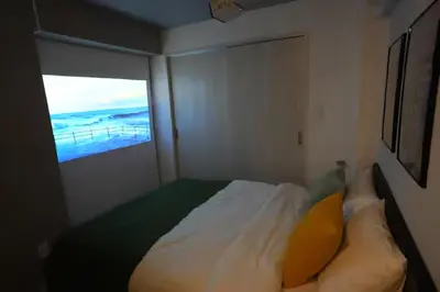 a small bedroom with a bed with a view of the ocean at Monzen-Nakacho Stylish 1LDK with 2 Double Beds in Tokyo