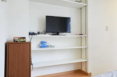 a room with white shelves and a tv on a wall at 201 Nishi-Shinjuku-Gochome Station 5 minutes on foot in Tokyo