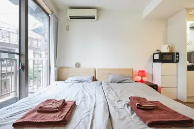 a bedroom with a large bed with towels on it at 201 Nishi-Shinjuku-Gochome Station 5 minutes on foot in Tokyo