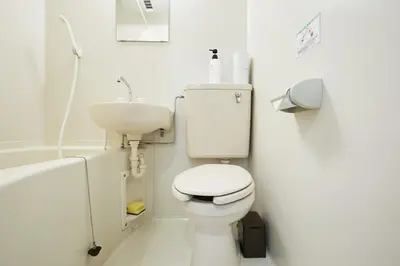a white bathroom with a toilet and a sink at 201 Nishi-Shinjuku-Gochome Station 5 minutes on foot in Tokyo