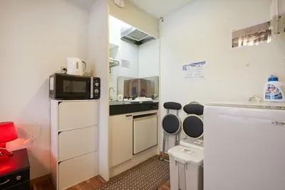 a small kitchen with a sink and a microwave at 201 Nishi-Shinjuku-Gochome Station 5 minutes on foot in Tokyo