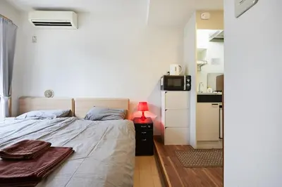 a bedroom with a bed and a small kitchen at 201 Nishi-Shinjuku-Gochome Station 5 minutes on foot in Tokyo