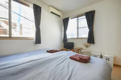 a bedroom with a large bed and two windows at 202 Nishi-Shinjuku Gochome Station 5 minutes on foot in Tokyo