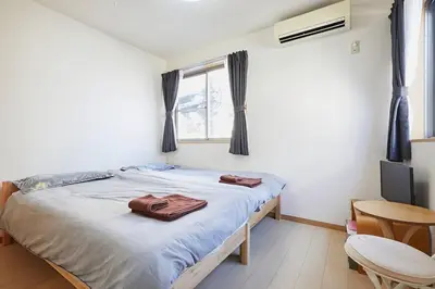 a bedroom with a bed and a table and a window at 202 Nishi-Shinjuku Gochome Station 5 minutes on foot in Tokyo