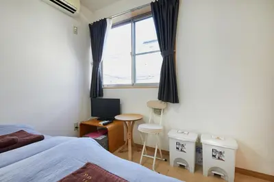 a bedroom with a bed and a desk and a window at 202 Nishi-Shinjuku Gochome Station 5 minutes on foot in Tokyo