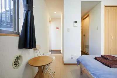 a bedroom with a bed and a table and a window at 202 Nishi-Shinjuku Gochome Station 5 minutes on foot in Tokyo