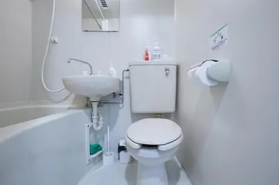 a white bathroom with a toilet and a sink at 202 Nishi-Shinjuku Gochome Station 5 minutes on foot in Tokyo