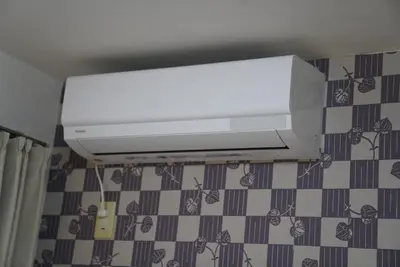 a white air conditioner on a wall in a bathroom at 301 Nishi-Shinjuku-Gochome Station 5 minutes on foot in Tokyo