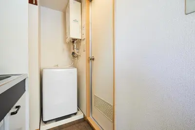 a small kitchen with a white refrigerator in a room at 301 Nishi-Shinjuku-Gochome Station 5 minutes on foot in Tokyo
