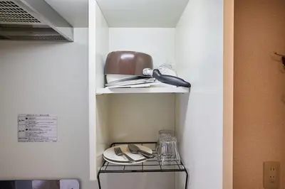 a room with a shelf with plates and a pot at 301 Nishi-Shinjuku-Gochome Station 5 minutes on foot in Tokyo