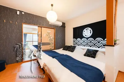 a bedroom with two beds and a black wall at Senjushuku FUJI 201 \u5317\u5343\u4f4f in Tokyo