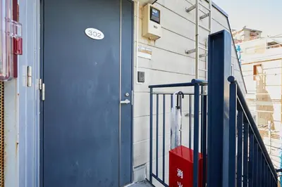 a blue door on the side of a building at 302 Nishi-Shinjuku-Gochome Station 5 minutes on foot in Tokyo