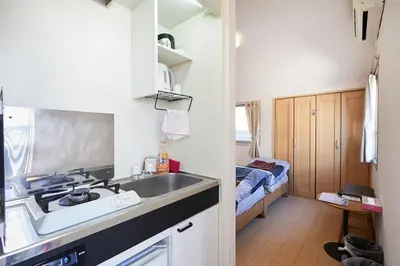 a small kitchen with a sink and a bed at 302 Nishi-Shinjuku-Gochome Station 5 minutes on foot in Tokyo