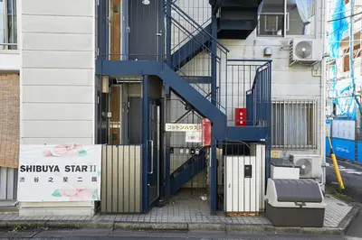 a building with a blue staircase in front of a building at 302 Nishi-Shinjuku-Gochome Station 5 minutes on foot in Tokyo