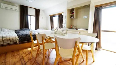 a dining room with a table and chairs and a bed at 103 3-minute walk to Nishi-Shinjuku 5-chome Station in Tokyo