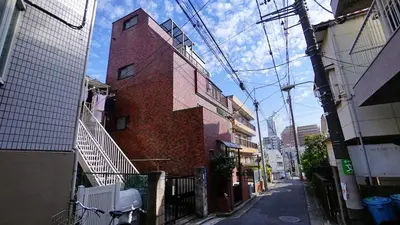 a brick building on a street in a city at 103 3-minute walk to Nishi-Shinjuku 5-chome Station in Tokyo